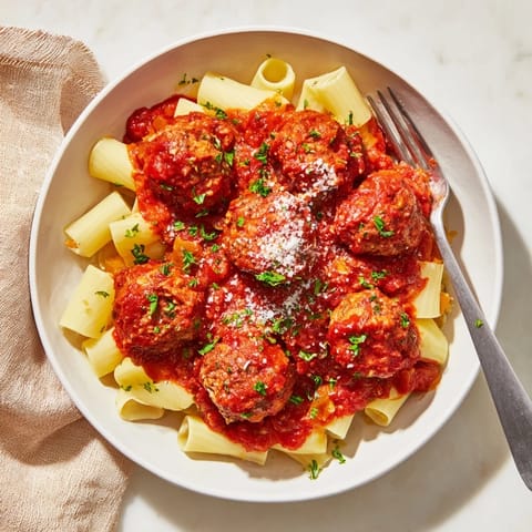 Freshly baked turkey meatballs garnished with chopped parsley and grated Parmesan, nestled on a bed of fluffy white rice for a healthy meal.