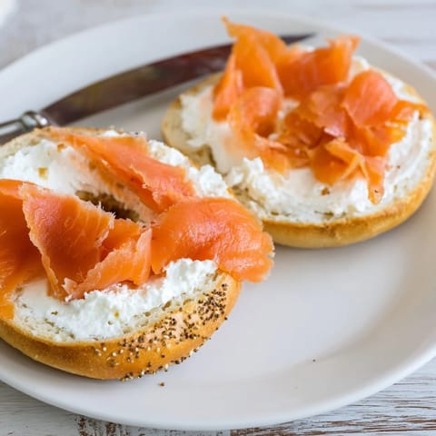 Classic New York style bagel with lox and cream cheese garnished with capers, served on a rustic wooden board.