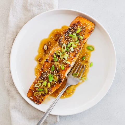Sizzling Honey Garlic Salmon glazed in a sweet-savory sauce, paired with steamed broccoli and sprinkled with sesame seeds.