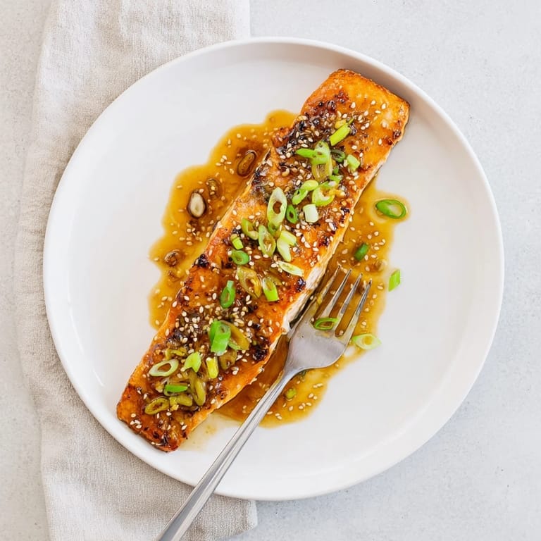 Sizzling Honey Garlic Salmon glazed in a sweet-savory sauce, paired with steamed broccoli and sprinkled with sesame seeds.