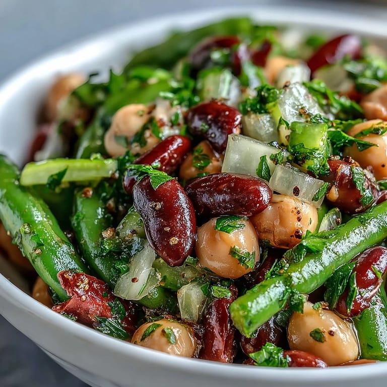 Fresh parsley garnishes this bright Three-Bean Salad, showcasing colorful beans in a jar for easy transport to picnics.